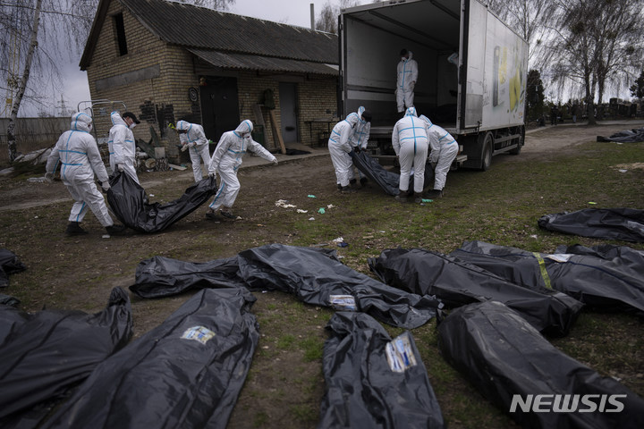 [부차=AP/뉴시스]우크라이나 키이우 외곽 부차에서 자원봉사자들이 러시아군에 살해된 민간인들의 시신을 트럭에 싣고 있다. 2022.04.13.