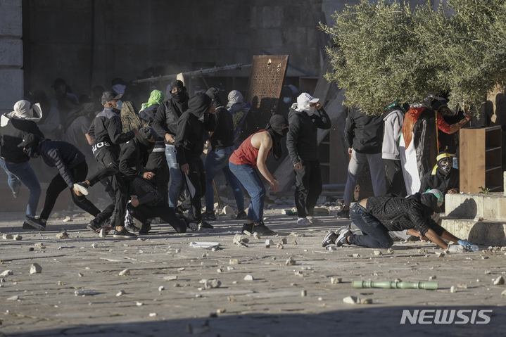 [예루살렘=AP/뉴시스]금요일인 15일 새벽 기도를 위해 예루살렘 알 아크사 사원에 수천명의 팔레스타인 군중이 모여든 가운데 폭력 사태가 발생한 것으로 예상한 이스라엘 경찰이 사원으로 대거 진입하면서 양측 간에 충돌이 발생, 팔레스타인인 최소 59명이 부상했다. 최루탄 등을 발사하는 이스라엘 경찰을 향해 돌 등을 던지며 저항하는 팔레스타인인들 모습. 2022.4.15