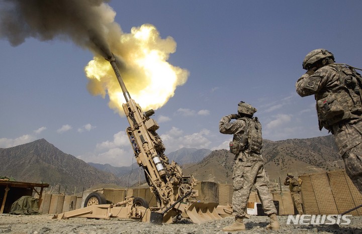 [쿠나르(아프가니스탄)=AP/뉴시스] 지난 2011년 7월8일(현지시간) 아프가니스탄 쿠나르 주의 보스틱 전진 기지에서 미군 병사들이 155mm 곡사포를 발사하고 있다. 2022.4.22 photo@newsis.com