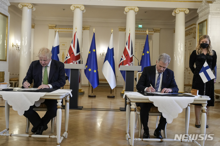 [헬싱키=AP/뉴시스] 보리스 존슨(왼쪽) 영국 총리와 사울리 니니스퇴 핀란드 대통령이 11일(현지시간) 핀란드 헬싱키 대통령궁에서 안전보장 협정 문서에 서명하고 있다. 스웨덴과 핀란드가 러시아의 우크라이나 침공 이후 북대서양조약기구(나토) 가입을 검토 중인 가운데 존슨 총리는 두 나라와 상호 안전보장 협정을 체결했다. 2022.05.12. 