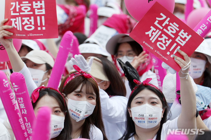 [서울=뉴시스] 조성우 기자 = 대한간호협회와 전국보건의료노조 조합원들이 12일 오후 서울 종로구 광화문 동화면세점 앞에서 열린 2022 국제 간호사의 날 결의대회에서 간호법 제정, 간호사 1인당 적정 환자 수 기준 마련, 불법진료(의료) 근절 등을 요구하며 구호를 외치고 있다. 2022.05.12. xconfind@newsis.com