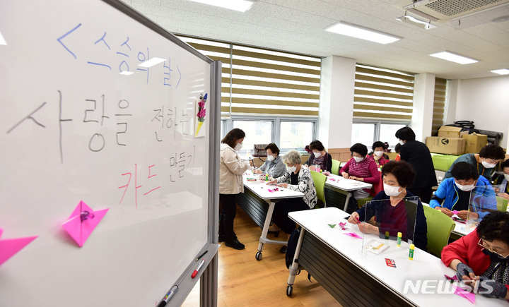 [대구=뉴시스] 이무열 기자 = 스승의 날을 이틀 앞둔 13일 대구 남구 평생학습관에서 문해학당 어르신들이 선생님에게 전달할 카네이션을 접고 있다. 2022.05.13. lmy@newsis.com