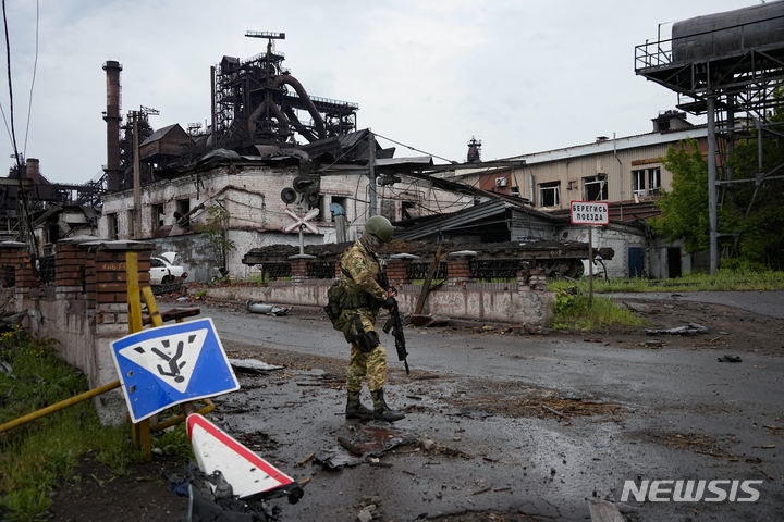 [마리우폴=AP/뉴시스] 18일(현지시간) 우크라이나 동부 도네츠크인민공화국(DPR) 산하 마리우폴에서 러시아 군인이 파괴된 일리치 제철소 부근을 순찰하고 있다. 2022.05.19.