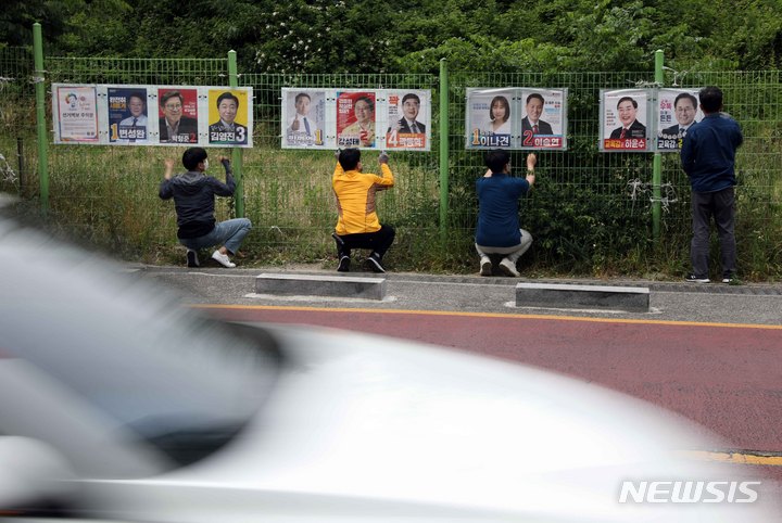 [부산=뉴시스] 하경민 기자 = 제8회 전국동시지방선거 공식 선거운동 첫날인 19일 오전 부산 수영구 망미1동 행정복지센터 앞에서 구청 관계자들이 선거벽보를 설치하고 있다. 2022.05.19. yulnetphoto@newsis.com