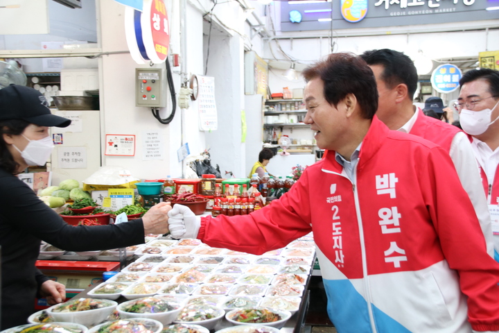 [거제=뉴시스] 홍정명 기자= 박완수 국민의힘 경남도지사 후보가 20일 거제시 고현시장을 찾아 상인과 주먹인사를 하고 있다.(사진=박완수 선거사무소 제공) 2022.05.20. photo@newsis.com *재판매 및 DB 금지