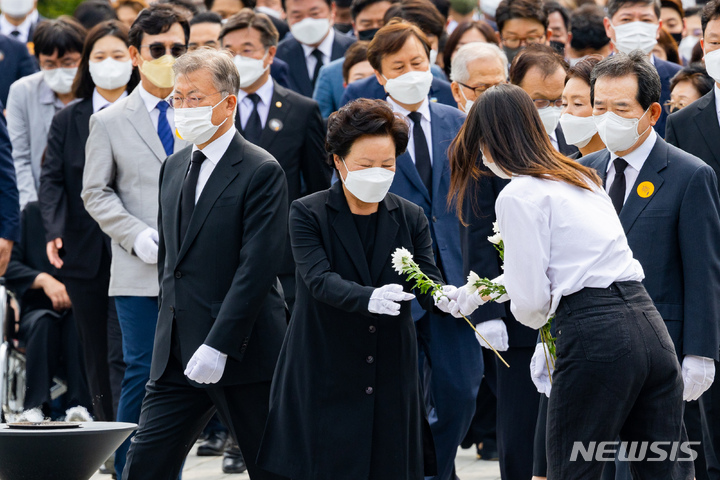 [김해=뉴시스] 전진환 기자 = 권양숙 여사가 23일 오후 경남 김해시 봉하마을에서 고 노무현 대통령의 13주기를 맞아 헌화를 위해 국화를 받고 있다. (공동취재사진) 2022.05.23. photo@newsis.com