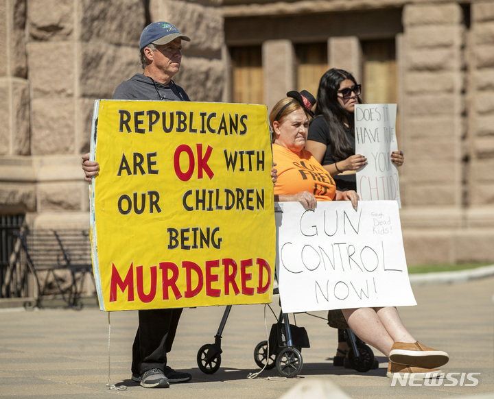 [오스틴=AP/뉴시스] 25일(현지시간) 미 텍사스주 오스틴의 주지사 자택 앞에서 총기 반대 단체인 '맘스 디맨드 액션'(Moms Demand Action)이 주최한 시위 참석자들이 손팻말을 들고 있다. 24일 유밸디의 롭 초등학교에서 총격범 살바도르 라모스(18)의 총기 난사로 학생 19명과 교사 2명이 숨졌고 라모스는 사살됐다. 2022.05.26.