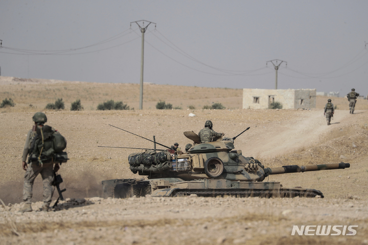 [시리아=AP/뉴시스]터키 탱크와 군대가 2019년 10월 15일 시리아 만비즈 마을 근처에 배치돼 있다. 2022.06.17