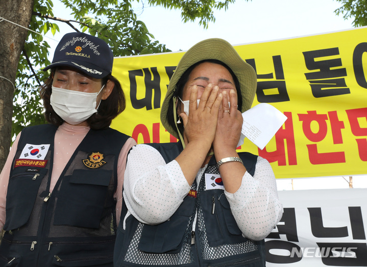 [서울=뉴시스] 김금보 기자 = 지난 14일 오전 서울 용산구 대통령집무실 인근에서 6.25전쟁국군포로유족회 회원들이 유가족지위 인정을 요구하는 집회를 열고 발언하고 있다. 이날 유족들은 국군 포로로 잡혀 북한 땅에서 강제 노역등에 시달리다 사망하거나 공개처형당한 아버지들의 사연을 알리며 슬픔에 흐느꼈다. 이들은 모두 유자녀 지위를 인정받고 있지 못한데 당시 국군 포로들을 모두 1953년 전사 처리하면서 이후 출생자들을 유가족으로 인정할 수 없다는 정부 행정상 문제 때문이다. 2022.06.14. kgb@newsis.com