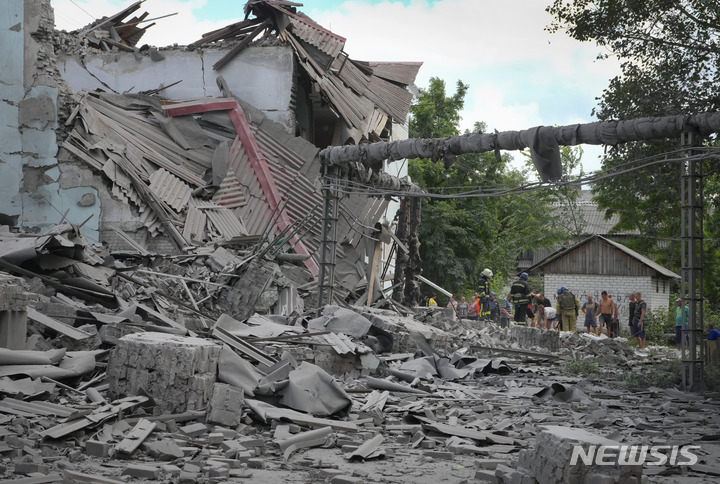 [리시찬스크=AP/뉴시스] 16일(현지시간) 우크라이나 루한시크주 리시찬스크에 러시아군의 공습이 지나간 후 구조대와 지역 주민들이 건물 잔해 속에서 희생자 시신을 수습하고 있다. 2022.06.17.