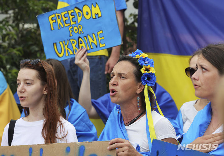 [브뤼셀=AP/뉴시스] 23일(현지시간) 벨기에 브뤼셀의 유럽연합(EU) 정상회의가 열리는 EU 본부 앞에서 우크라이나의 EU 가입을 지지하는 사람들이 시위하고 있다. EU 정상들은 이날 우크라이나의 EU 후보국 지위 자격 부여 방안을 승인할 것으로 알려졌다. 2022.06.23.