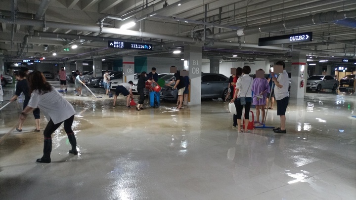지난 23일 서울 송파구 한 브랜드 대단지에서 발생한 침수 하자로 입주민들이 빗물을 퍼나르고 있다.(사진 제공=해당 단지 입주민 측) *재판매 및 DB 금지