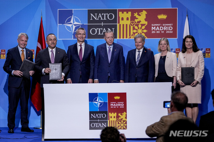 [마드리드=AP/뉴시스] 레제프 타이이프 에르도안(가운데) 튀르키예 대통령이 28일(현지시간) 스페인 마드리드에서 핀란드와 스웨덴의 북대서양조약기구(NATO·나토) 가입을 지지하는 양해각서에 서명 후 관계자들과 기념 촬영을 하고 있다. 에르도안 대통령은 기존의 반대 입장을 철회하고 스웨덴과 핀란드의 나토 가입을 지지하기로 했다. 왼쪽부터 페카 하비스토 핀란드 외무장관, 메블뤼트 차우쇼을루 터키 외무장관, 옌스 스톨텐베르그 나토 사무총장, 에르도안, 사울리 니니스퇴 핀란드 대통령, 마그달레나 안데르손 스웨덴 총리, 안 린데 스웨덴 외무장관. 2022.06.29.