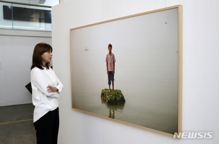 [서울=뉴시스] 박진희 기자 = 프리랜서 손정은 전 MBC 아나운서가 1일 서울 종로구 토탈미술관에서 방탄소년단 팬클럽 아미(ARMY)들의 기획으로 열린 현대미술 특별전 'Beyond the Scene'(비욘드 더 신) 전시 작품 이대성의 '사라지는 섬의 해변에서'를 감상하고 있다. 이 작품의 주제는 자연과 환경문제에 관한 것이다. 2022.07.01. pak7130@newsis.com