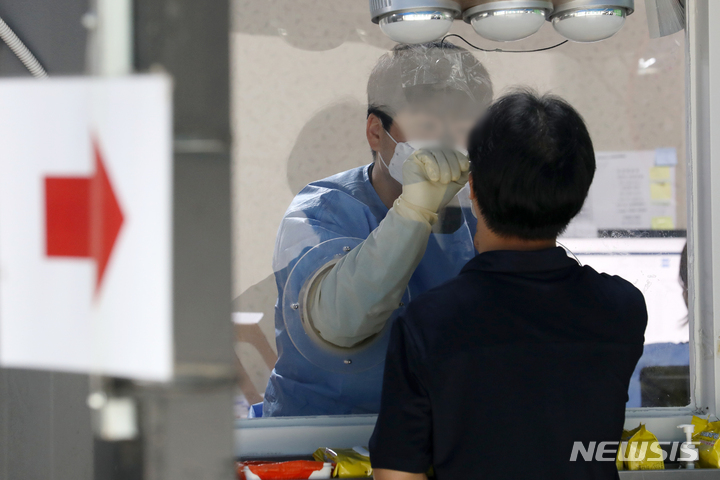 [서울=뉴시스] 조성우 기자 = 코로나19 신규 확진자가 1만9371명으로 4주 만에 최고치를 기록하는 등 증가세를 보이고 있는 6일 오전 서울 용산구 보건소 선별진료소에서 한 시민이 검사를 받고 있다. 2022.07.06. xconfind@newsis.com