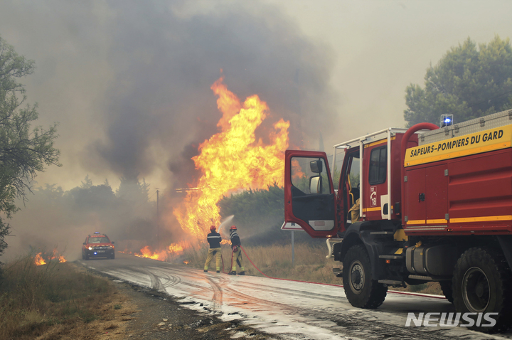 [가르( 프랑스)=AP/뉴시스] 프랑스 남부 지롱드 지방에서 발생한 화재로 7월 31일 소방대가 불길과 싸우고 있다. 최근의 폭염과 강풍으로 브르타뉴지방에서도 8월 6일과 7일 산불이 크게 번져 소도시 15개 이상이 주민을 대피시켰다. 