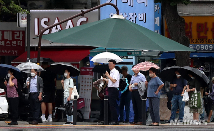[서울=뉴시스] 추상철 기자 = 비가 오락가락한 날씨를 보인 2일 오후 서울 도심에서 우산을 쓴 시민들이 대형 그늘막 아래에 모여 신호를 기다리고 있다. 2022.08.02. scchoo@newsis.com