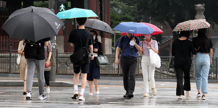 [서울=뉴시스] 김금보 기자 = 비가 내린 지난 3일 오전 서울 중구 세종대로사거리에서 시민들이 우산을 쓰고 이동하고 있다. 2022.08.03. kgb@newsis.com