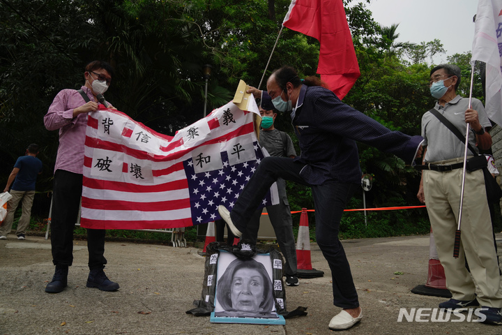 [홍콩=AP/뉴시스] 2022년 8월3일 홍콩 주재 미국 총영사관 밖에서 낸시 펠로시 미국 하원의장의 대만 방문에 항의하는 친중 시위대가 미국 국기를 거꾸로 들고 펠로시 하원의장의 사진을 짓밟고 있다. 2022.08.03.
