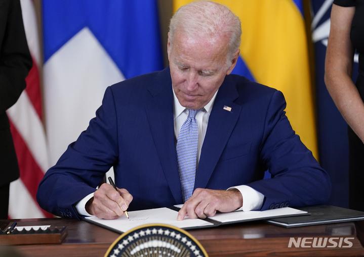 [워싱턴=AP/뉴시스] 조 바이든 미국 대통령이 9일(현지시간) 백악관 이스트룸에서 핀란드·스웨덴의 북대서양조약기구(NATO·나토) 가입 비준안에 서명하고 있다. 2022.08.10.