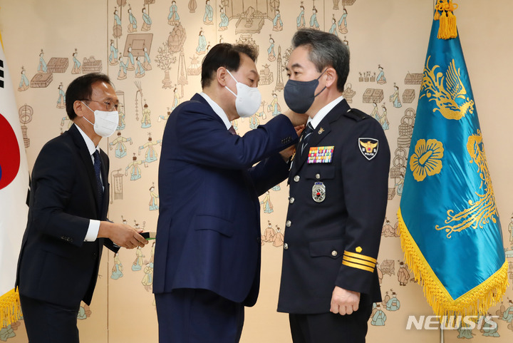 [서울=뉴시스] 전신 기자 = 윤석열 대통령이 10일 서울 용산 대통령실 청사에서 열린 윤희근 경찰청장 임명장 수여식에서 계급장을 달아주고 있다. 2022.08.10. photo1006@newsis.com