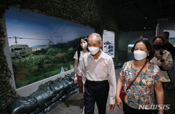 [서울=뉴시스] 조수정 기자 = 베트남 전쟁 당시 한국군에 의한 민간인 학살 피해로 가족을 잃은 응우옌 티 탄(오른쪽) 씨와 당시 남베트남 민병대 소속으로 학살 현장을 목격한 응우옌 득쩌이(오른쪽 두번째) 씨가 지난해 8월11일 서울 용산구 전쟁기념관 해외파병실에서 베트남전 관련 전시를 보며 설명을 듣고 있다. 2022.08.11. chocrystal@newsis.com