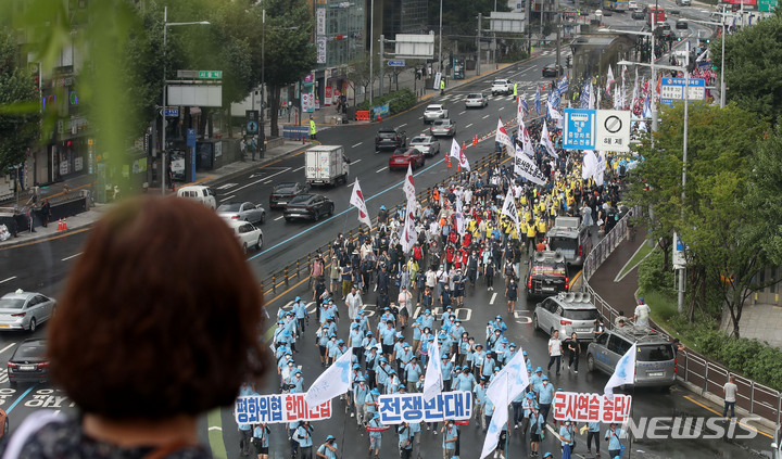 [서울=뉴시스] 조수정 기자 = 13일 오후 서울 중구 숭례문 앞에서 열린 8·15 전국노동자대회 및 자주평화통일대회 참가자들이 세종대로에서 출발, 용산 대통령실을 향해 행진하는 모습을 시민들이 지켜보고 있다. 2022.08.13. chocrystal@newsis.com