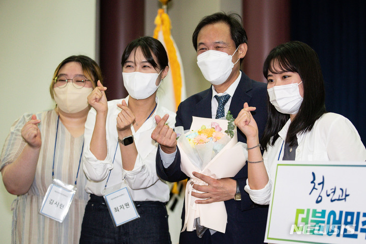 [서울=뉴시스] 김선웅 기자 = 우상호 더불어민주당 비상대책위원장이 15일 서울 여의도 국회 의원회관에서 열린 민주당 전국청년당 주최 청년공감 청년소통 열린간담회에서 청년당원들로부터 꽃다발을 건네 받은 후 기념촬영을 하고 있다. (공동취재사진) 2022.08.15. photo@newsis.com