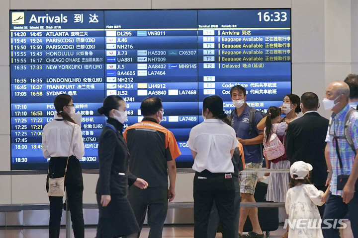 [도쿄=AP/뉴시스] 23일 일본 도쿄의 하네다 공항 입국장에서 마스크를 쓴 사람들이 승객 도착을 기다리고 있다. 2022.08.24