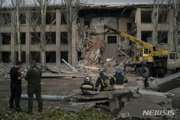 [미콜라이프=AP/뉴시스]구조대원들이 28일(현지시간) 우크라이나 미콜라이프에서 러시아군의 공격으로 학교가 심하게 파손된 후 한 여성이 숨진 채 발견된 현장에서 잔해를 치우고 있다. 2022.09.28.