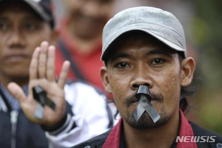 [말랑(인도네시아)=AP/뉴시스] 한 남성이 3일(현지시간) 인도네시아 말랑에서 축구장 압사 사고 희생자를 기리기 위해 집회에 참가해 애도의 상징으로 입술에 검은 리본을 붙이고 있다. 2022.10.05.