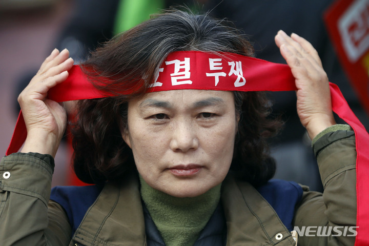 [서울=뉴시스] 최동준 기자 = 25일 서울 종로구 서울시교육청 앞에서 열린 전국학교비정규직노조 서울지부, 전국교육공무직본부 서울지부의 '집단임금교섭 투쟁승리' 총파업대회에서 한 참가자가 머리끈을 묶고 있다. 2022.11.25. photocdj@newsis.com