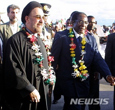 【하라레=AFP/뉴시스】 모하마드 하타미 이란 대통령(왼쪽)이 17일(현지시간) 짐바브웨 하라레 국제공항에 도착해 로버트 가브리엘 무가베 짐바브웨 대통령과 나란히 걸어가고 있다. 하타미 대통령은 짐바브웨에서 이틀간 무가베 대통령과 회담을 가질 예정이다. 2005.01.18