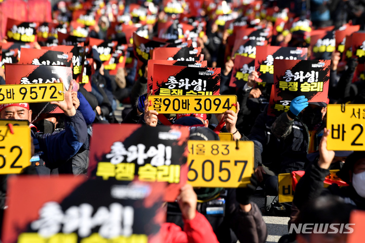 [광주=뉴시스] 이영주 기자 = 8일 오후 광주 광산구 평동역 교차로에서 열린 화물연대 광주지역본부의 총파업 15일차 총력투쟁 결의대회 도중 화물운수 노동자들이 손팻말과 번호판을 들고 집회에 참여하고 있다. 2022.12.08. leeyj2578@newsis.com