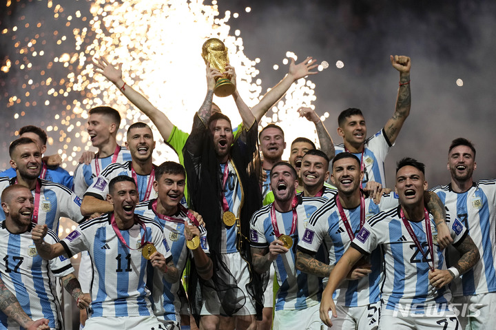 [루사일=AP/뉴시스] 아르헨티나의 리오넬 메시가 18일(현지시간) 카타르 루사일 스타디움에서 열린 2022 카타르 월드컵 정상에 올라 우승컵을 들고 동료들과 기념사진을 찍으며 환호하고 있다. 아르헨티나는 연장 3-3 무승부 끝에 승부차기로 프랑스를 4-2로 꺾고 36년 만에 정상에 올랐다. 2022.12.19.