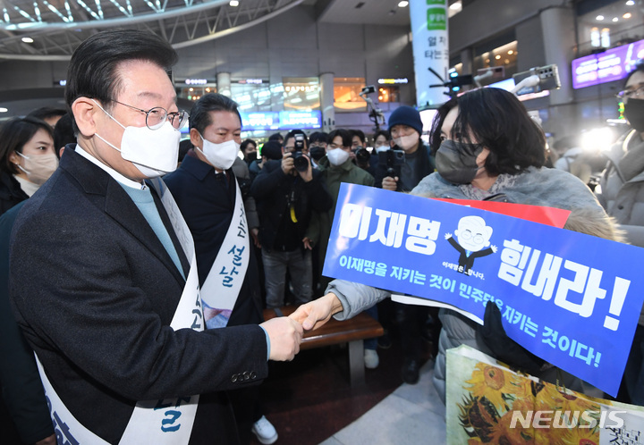 [서울=뉴시스] 이영환 기자 = 이재명 더불어민주당 대표가 지난 20일 오전 서울 용산구 용산역에서 설 귀성 인사를 하며 지지자와 악수를 하고 있다. (공동취재사진) 2023.01.20. photo@newsis.com