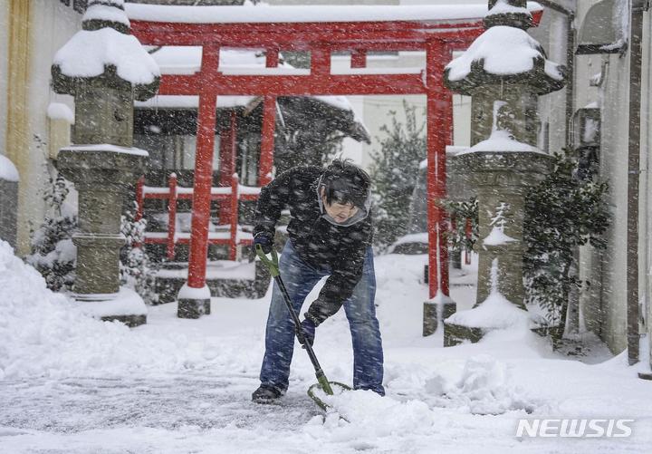 [돗토리=AP/뉴시스] 25일 일본 서부 돗토리현에서 한 남성이 신사 앞에 쌓인 눈을 치우고 있다. (사진은 기사 내용과 관계 없음)2023.01.25.