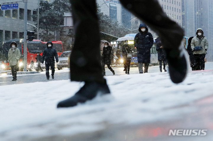 [서울=뉴시스] 최동준 기자 = 눈이 내리고 있는 지난 26일 서울 명동성당 사거리에서 시민들이 출근하고 있다. 2023.01.26. photocdj@newsis.com