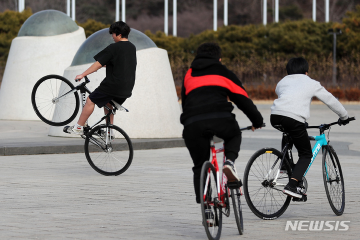 [서울=뉴시스] 백동현 기자 = 오전과 비교해 비교적 포근한 날씨를 보인 지난달 29일 오후 서울 송파구 올림픽공원에서 한 시민이 반팔, 반바지를 입고 자전거를 타고 있다. 2023.01.29. livertrent@newsis.com