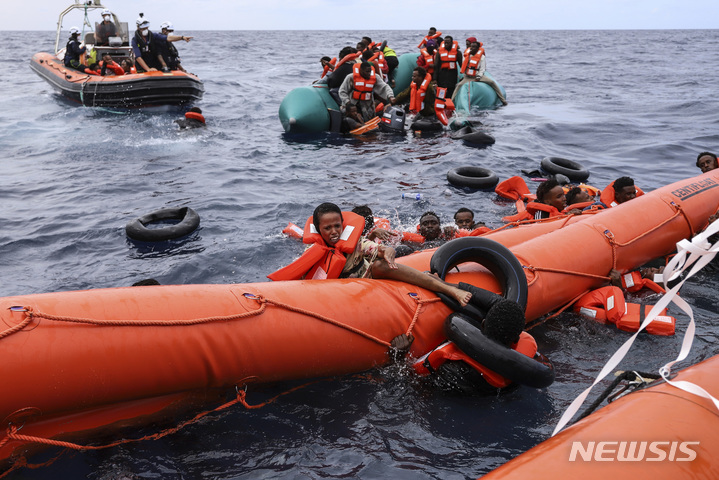 [리비아해역=AP/뉴시스] 리비아 해안에서56km떨어진 지중해에서 고무보트를 타고 유럽을 향해 가다가 조난한 난민들이 리비아 해양경찰에 의해 구조되는 광경( 2021년 10월 18일 AP자료사진). 2024.04. 23. 