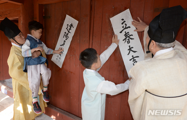 [울산=뉴시스] 배병수 기자 = 24절기 중 첫 번째 절기인 입춘(立春)을 이틀 앞둔 2일 오전 울산 중구 울산향교에서 유림들과 학생들이 ‘입춘대길(立春大吉)’, ‘건양다경(建陽多慶)’ 등이 적힌 입춘첩을 붙이고 있다. 2023.02.02. bbs@newsis.com.