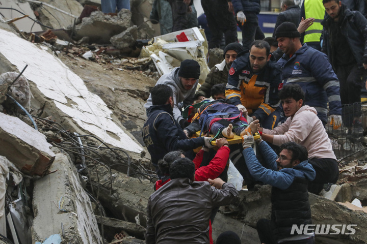 [아다나=AP/뉴시스] 6일(현지시간) 튀르키예 남부에서 발생한 규모 7.8의 강진으로 아다나에서 구조대와 주민들이 무너진 건물 잔해에 있던 생존자를 구조해 옮기고 있다.