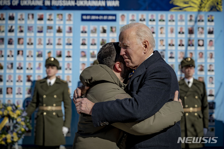 [키이우=AP/뉴시스] 조 바이든(오른쪽) 미국 대통령이 20일(현지시각) 우크라이나 키이우를 깜짝 방문해 러시아-우크라이나 전쟁에서 전사한 군인의 사진이 붙어 있는 추모의 벽에 헌화한 뒤 볼로디미르 젤렌스키 우크라이나 대통령과 작별 인사를 하고 있다. 2023.02.21.