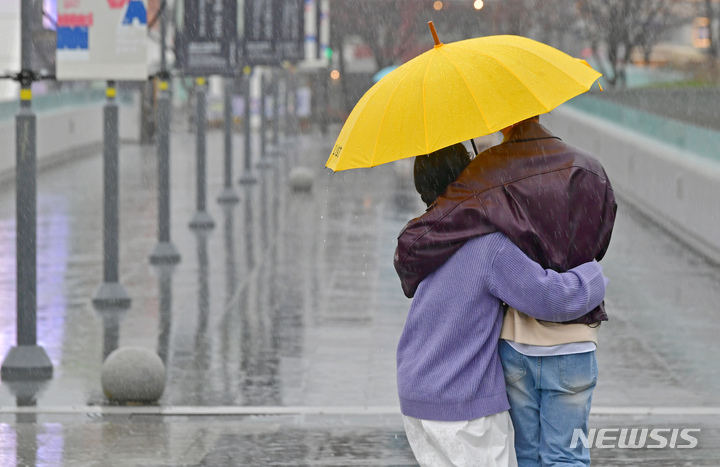 [광주=뉴시스] 이영주 기자 = 비가 내리는 지난 12일 오전 광주 동구 5·18민주광장에서 한 연인이 우산을 쓴 채 걷고 있다. 2023.03.12. leeyj2578@newsis.com