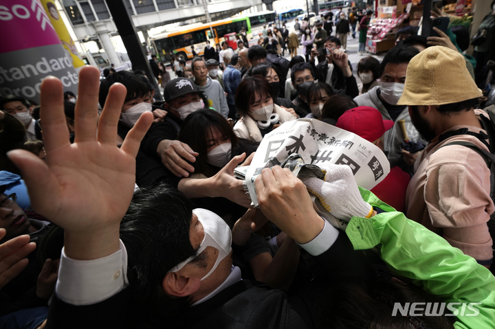 [도쿄=AP/뉴시스] 일본팀이 미국팀을 꺽고 제5회 월드베이스볼 클래식(WBC)을 제패한 뉴스를 실은 요미우리 신문의 호외가 22일 도쿄 시내에서 배포되자 행인들이 몰려 앞다퉈 받아가고 있다. 2023.03.22