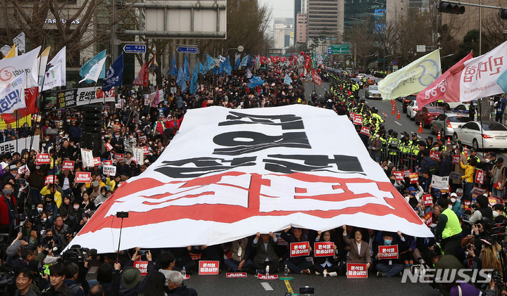 [서울=뉴시스] 최진석 기자 = 25일 오후 서울 중구 서울광장 인근에서 열린 '윤석열정권 심판 3.25행동의 날'에서 참석자들이 윤석열 정권 심판이 적힌 대형 현수막을 펼치고 있다. 2023.03.25