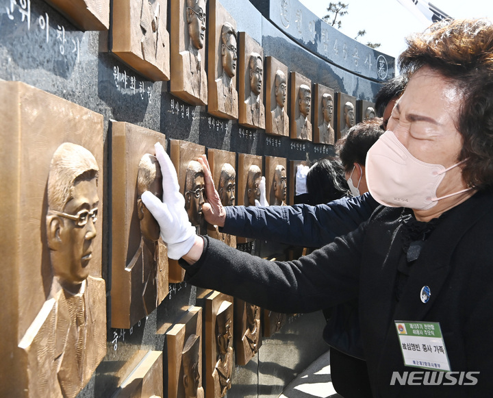 [평택=뉴시스] 김종택 기자 = 26일 경기도 평택시 해군 제2함대 사령부에서 열린 '제13주기 천안함 46용사 추모식'에서 유가족이 추모비에 새겨진 얼굴을 어루만지고 있다. 이날 열린 추모식에는 당시 숨진 군인 유가족과 천암함 승조원, 해군 관계자 등 200여 명이 참석했다. 2023.03.26. jtk@newsis.com