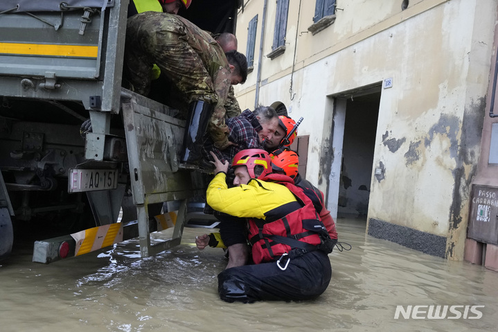 [카스텔 볼로네제=AP/뉴시스] 17일(현지시각) 이탈리아 에밀리아-로마냐주 카스텔 볼로네제 마을에서 소방관들이 노인들을 구조해 트럭에 태우고 있다. 가뭄이 이어지던 이탈리아 북부에 폭우가 내리면서 홍수가 발생, 최소 8명이 숨지고 주민 수천 명이 대피했다. 2023.05.18.