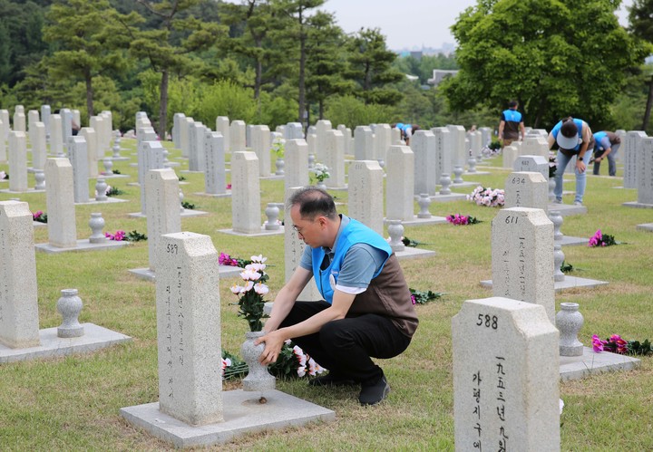 GS리테일 경영진들이 묘비 정화 활동 및 주변 환경 정비를 하고 있다(사진=GS리테일 제공) *재판매 및 DB 금지