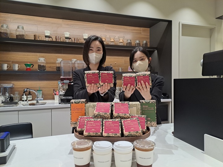 프리미엄 라운지 매니저들이 한정판 스페셜티 블랜드 Ourlet를 들고 포즈를 취하고 있다.(사진=신세계사이먼 제공) *재판매 및 DB 금지
